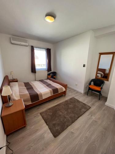a bedroom with a bed and a table and a mirror at Duna Apartman in Dunaszentmiklós