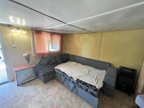 una sala de estar con un sofá y una mesa en Cozy Quiet Retreat 70km from Sofia, en Kyustendil