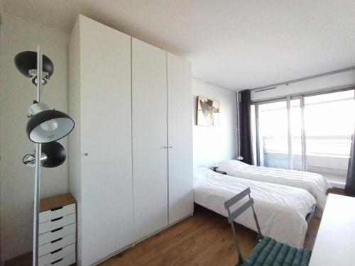 - une chambre avec des placards blancs, un lit et une fenêtre dans l'établissement Quai André Citroen - Paris 15, à Paris