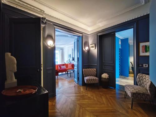 un couloir avec un salon aux murs bleus dans l'établissement Rue de Berri - Paris 8, à Paris