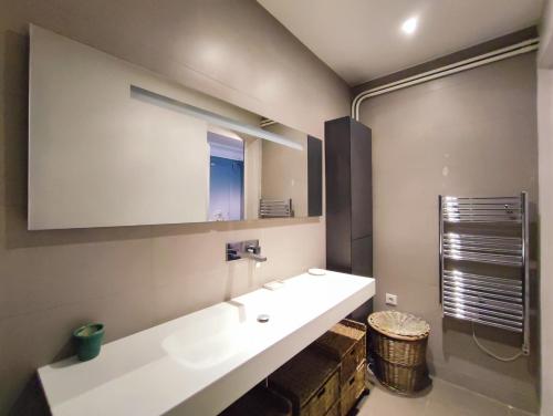 une salle de bain avec un lavabo blanc et un miroir dans l'établissement Rue de Berri - Paris 8, à Paris