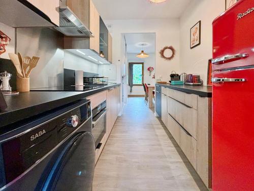  La cuisine est équipée d'un réfrigérateur rouge et d'un lave-vaisselle. dans l'établissement Stylish Apartment Disneyland Paris - Rentaway BnB, à Montévrain