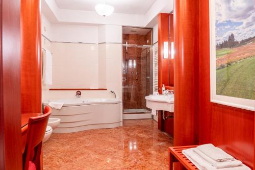 a bathroom with a tub and a toilet and a sink at Golf Hotel Cavaglià in Cavaglià