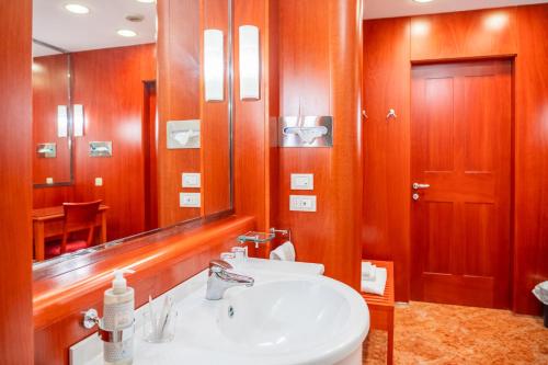 a bathroom with a sink and a mirror at Golf Hotel Cavaglià in Cavaglià