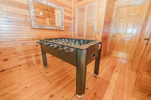 a foosball table in a room with wooden floors at A Slice of Heaven Cabin in Park Settlement