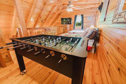 a large foosball table in a log cabin at A Slice of Heaven Cabin in Park Settlement