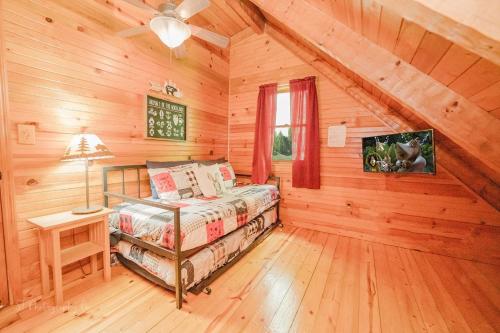a bedroom with a bed in a log cabin at A Slice of Heaven Cabin in Park Settlement
