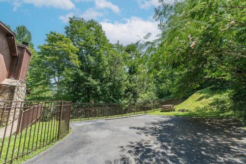 a driveway with a fence in front of a house at A Slice of Heaven Cabin in Park Settlement