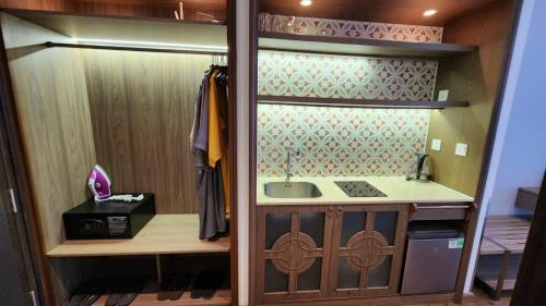 a kitchen with a sink and a counter in a room at APEC Mandala Mũi Né in Mui Ne