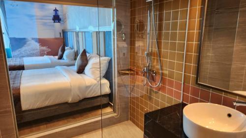 a bathroom with a bed and a sink and a shower at APEC Mandala Mũi Né in Mui Ne