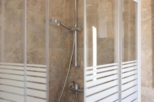 a shower with a glass door in a bathroom at Casa del Sole - Holiday Home in Diso