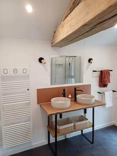 une salle de bain avec deux lavabos et un miroir dans l'établissement L'orée du bois, à Colombiers