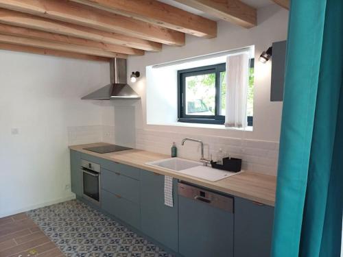 ColombiersにあるL'orée du boisのシンクと窓のあるキッチン