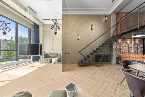 a living room with a staircase and a tv at ALL - Amberstone Lux Loft in Klaipėda