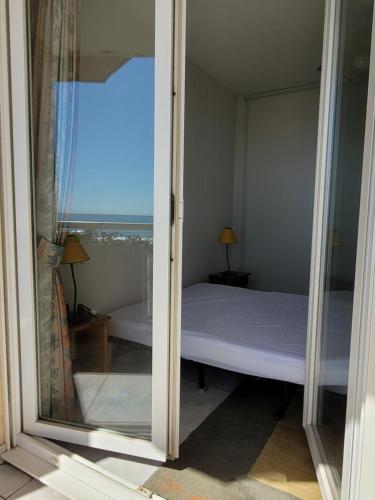 une chambre avec un lit et une vue sur l'océan dans l'établissement Appartement 80 m2, T 3 vue imprenable face à la mer, à Canet