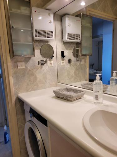 une salle de bain avec un lavabo et une machine à laver dans l'établissement Appartement 80 m2, T 3 vue imprenable face à la mer, à Canet