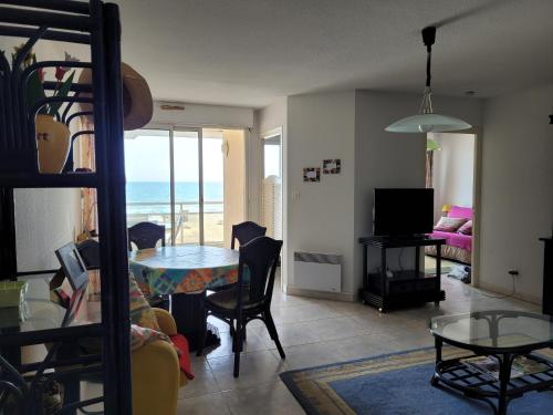- un salon avec une table et une vue sur l'océan dans l'établissement Appartement 80 m2, T 3 vue imprenable face à la mer, à Canet