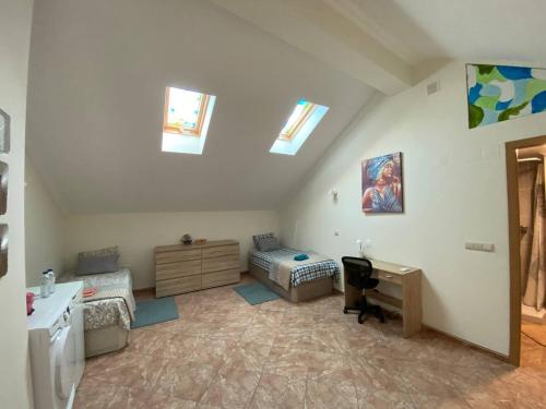 a attic room with a bed and a desk and windows at Guesthouse Milagre Centro Faro in Faro