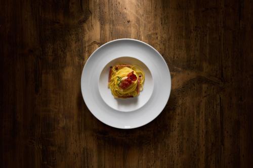a plate of food on a wooden table at Hotel Des Alpes in La Villa