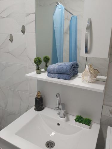 a white bathroom with a sink and a mirror at Studio Apartment - Prizren in Prizren