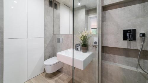 a bathroom with a sink and a toilet and a shower at VacationClub - Jana Matejki 1 Apartament 1 in Karpacz
