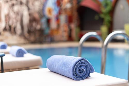 a towel on a table next to a swimming pool at Blue Sea Le Printemps in Marrakech