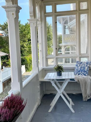 a white porch with a bench and a window at Nautic Hotell in Marstrand