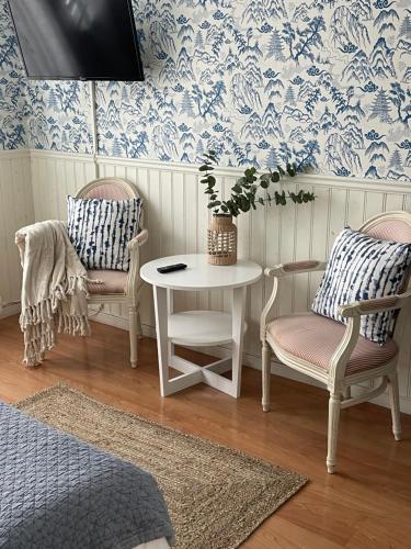 a room with two chairs and a table and a tv at Nautic Hotell in Marstrand