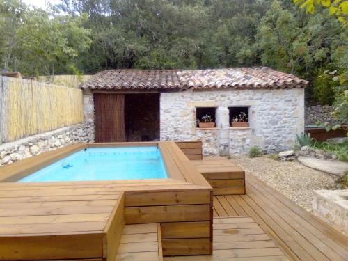 a hot tub in a backyard with a house at La chambre de Seraphin in Navacelles