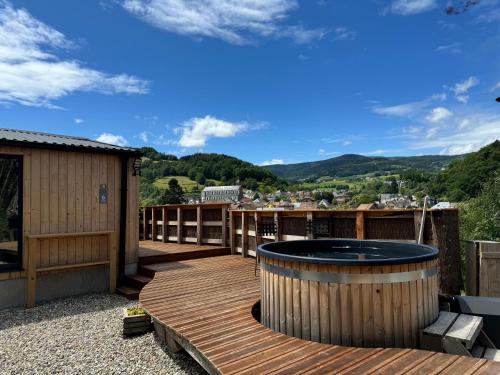 a deck with a hot tub on top of a house at Domaine des Constellations - Tiny Houses & Bains Nordiques in Orbey