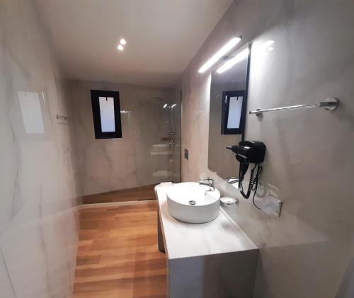 a bathroom with a white sink and a shower at Elite Centre in Rhodes Town