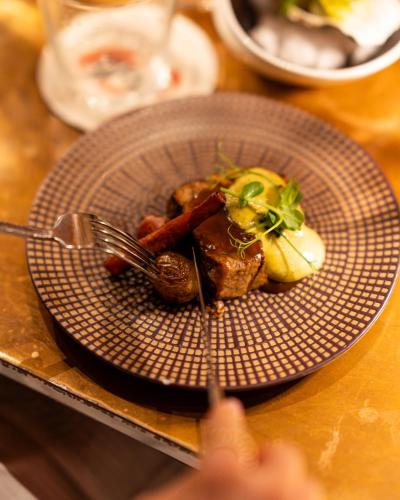 a plate of food with meat and vegetables on a table at DuoMo Hotel in Rimini