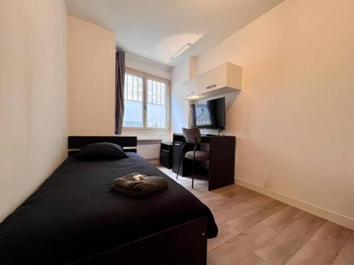 une chambre avec un lit, un bureau et une télévision dans l'établissement Studio 1 personne Au pied de la Citadelle, à Besançon