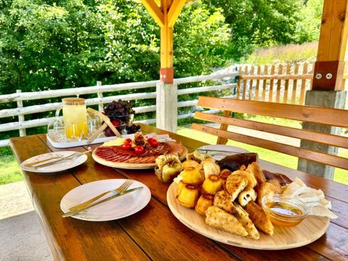 a wooden table with two plates of food on it at Mountain Retreat Jelovica in Kolašin