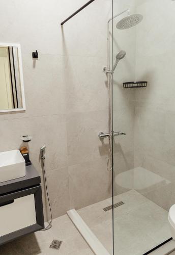 a shower with a glass door in a bathroom at Tskaltubo Apartments in Tskaltubo