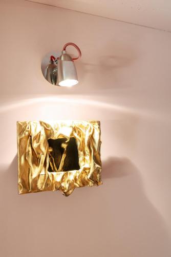 a gold light fixture on a wall with a lamp at ALL - Amberstone Lux Loft in Klaipėda