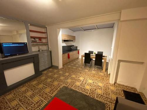 une pièce avec une cuisine avec une table et des chaises dans l'établissement Appartement Le Valbelle RDC Centre Ville Saint-Omer, à Saint-Omer