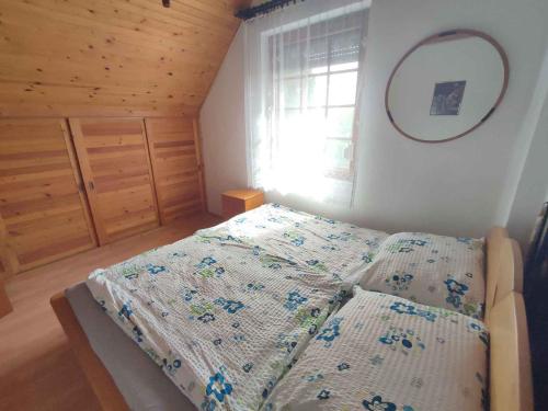 a bedroom with a bed with a comforter on it at Holiday home in Balatonkeresztur 44886 in Balatonkeresztúr