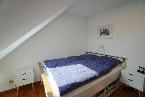 a bedroom with a bed with a blue blanket at Ferienwohnung "Wasserburg" in Ascheffel