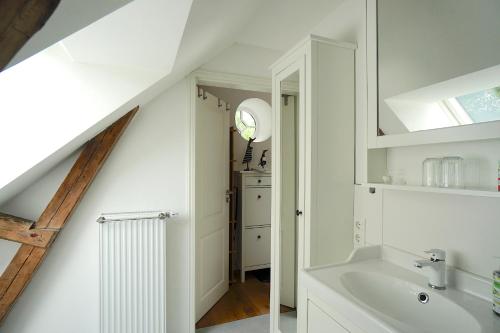 a white bathroom with a sink and a mirror at Ferienwohnung "Wasserburg" in Ascheffel