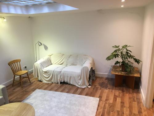 a living room with a bed and a table at Spacious duplex flat in London
