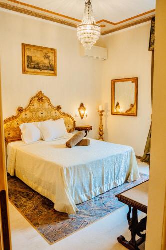 a bedroom with a large bed with a chandelier at La Casa Di Agartha in Bolsena