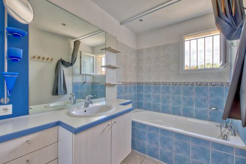 une salle de bain carrelée bleue avec un lavabo et une baignoire dans l'établissement Liberté Oléron - Belle maison proche de la plage, à Grand-Village-Plage