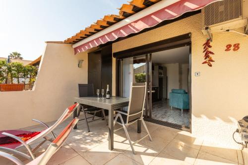 un patio avec une table et des chaises sur un balcon dans l'établissement Naturistecapdagde Villa Port Venus Serenity, au Cap d'Agde