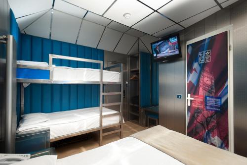 a room with two bunk beds and a television at Stylotel in London