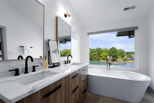 a white bathroom with two sinks and a large window at Elysian Shores w/Heated Pool & Optional Boat Rental in Mooresville