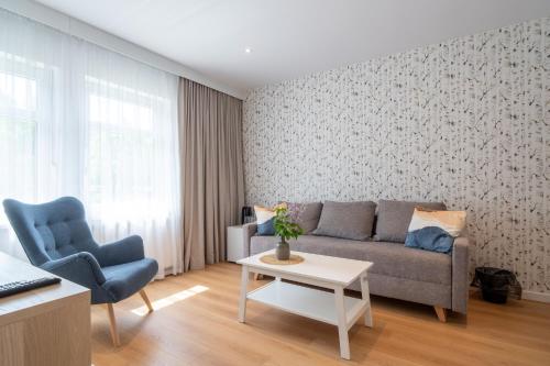 a living room with a couch and two chairs at Ośrodek Wypoczynkowy Zacisze in Śliwice