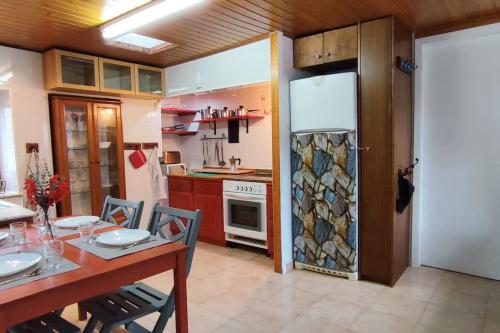 a kitchen with a table and a refrigerator at A Riquiña in Mondariz