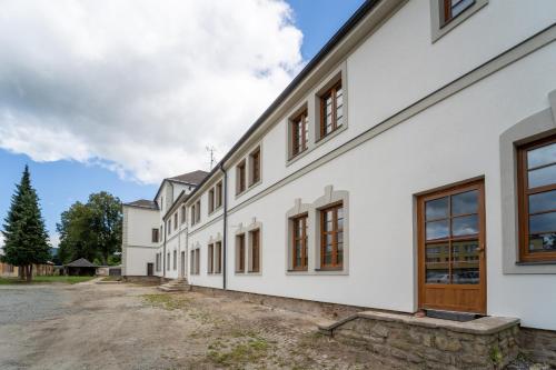 an exterior view of a white building with windows at Resort Červený dvůr in Rapotín