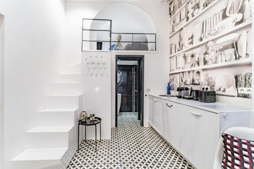 a kitchen with white cabinets and a black and white tile floor at Magnifique Appartement Hypercentre avec Terrasse in Bordeaux
